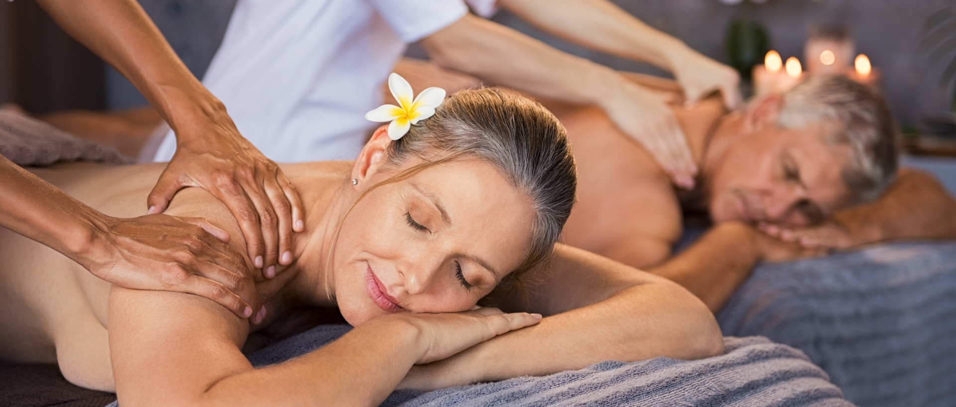 Senior couple in spa salon getting massage. Relaxed senior couple enjoying body treatment in a wellness center. Retired man and woman receiving a back massage from masseur in a spa salon.